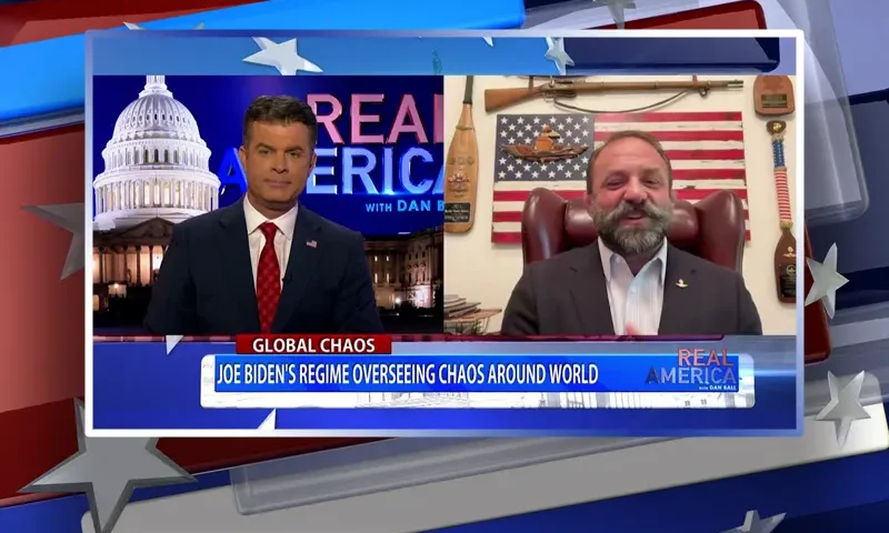 Video still from Real America on One America News Network showing a split screen of the host on the left side, and on the right side is the guest, Chad Robichaux.